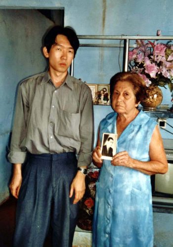 018 – Cláudio Tsuyoshi Suenaga e Odércia Villas Boas, com uma fotografia de Antônio Villas Boas às mãos